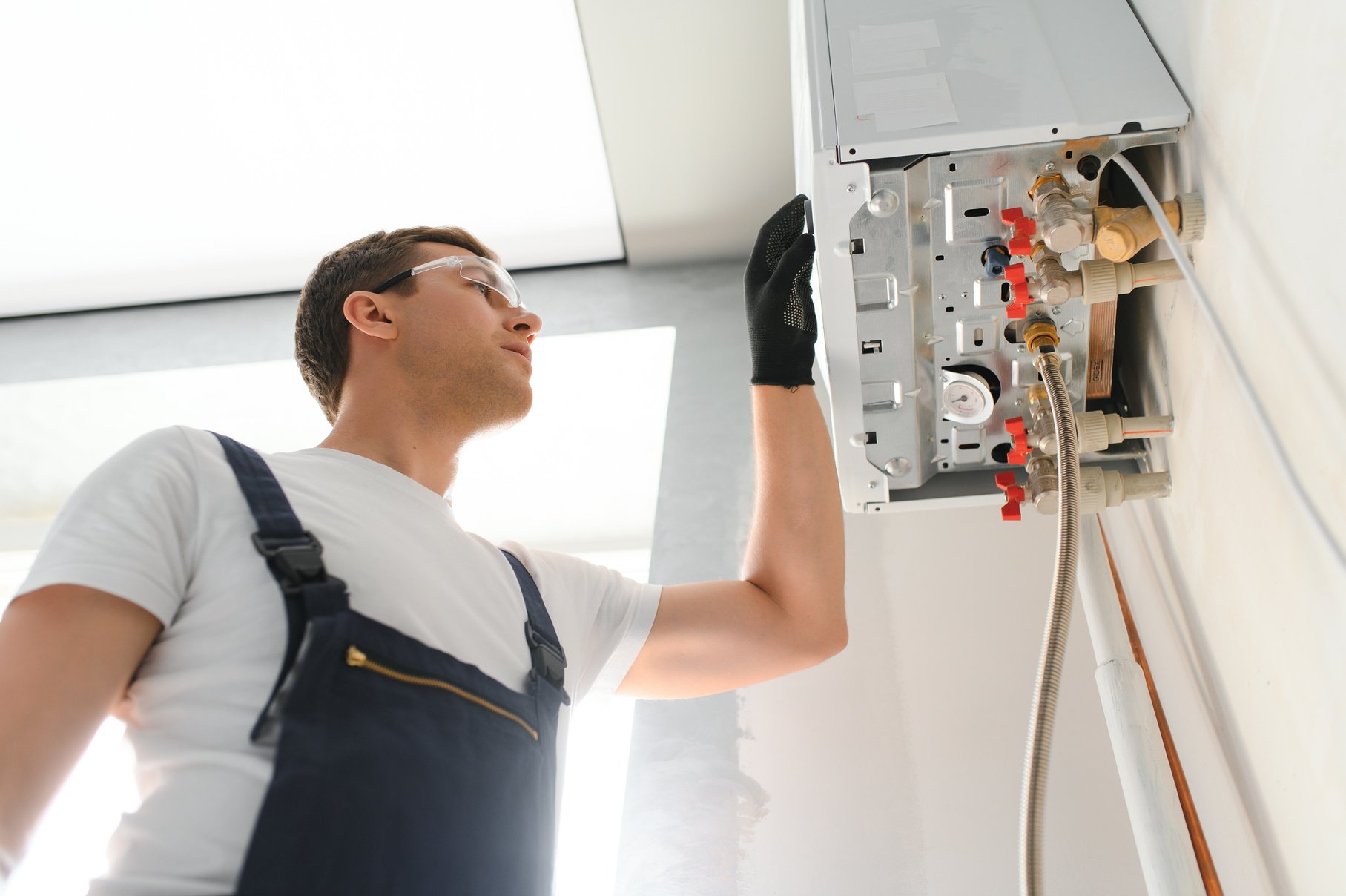 Professional plumber checking a boiler and pipes, boiler service concept